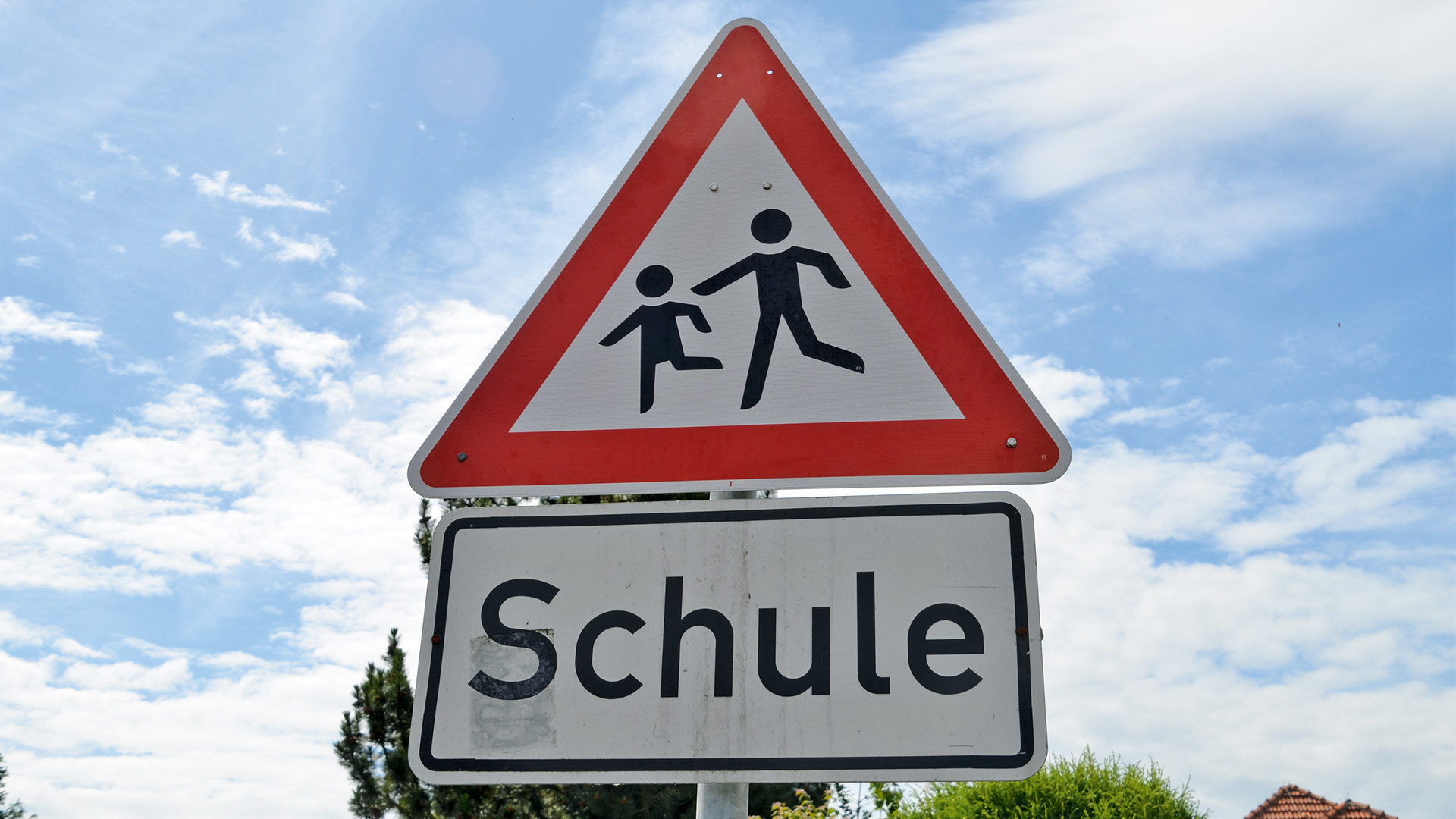 Verkehrsschild welches auf eine Schule und Kinder aufmerksam macht