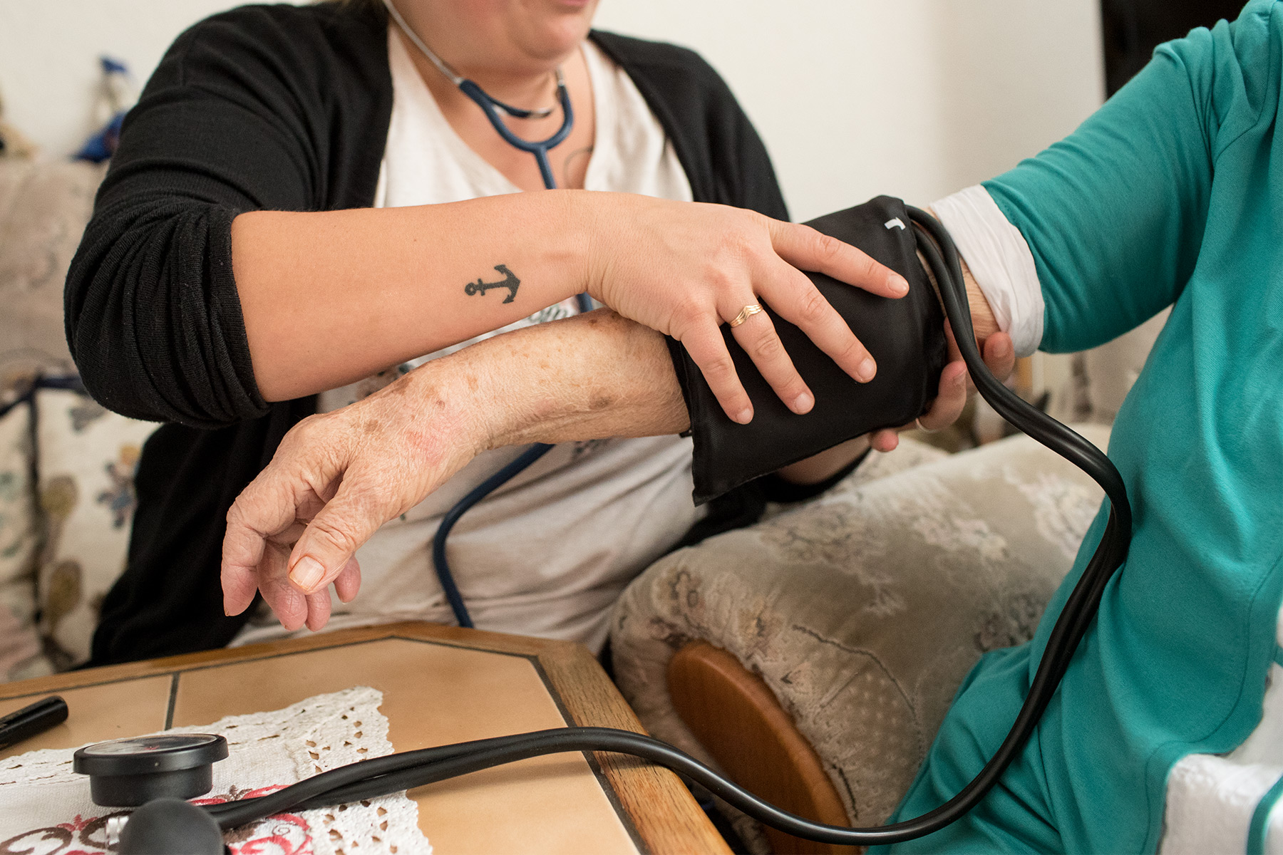 Pflegerin legt einer älteren Dame eine Blutdruckmessmanschette um